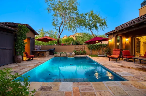 a view of a backyard with table and chairs under an umbrella