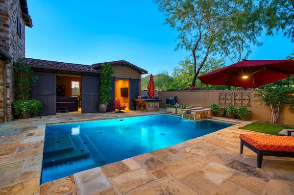 a view of a swimming pool with two chairs in a patio