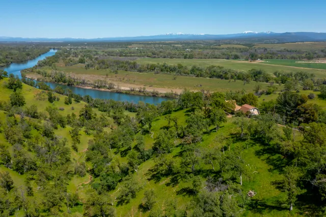 an aerial view of a houses with outdoor space and river