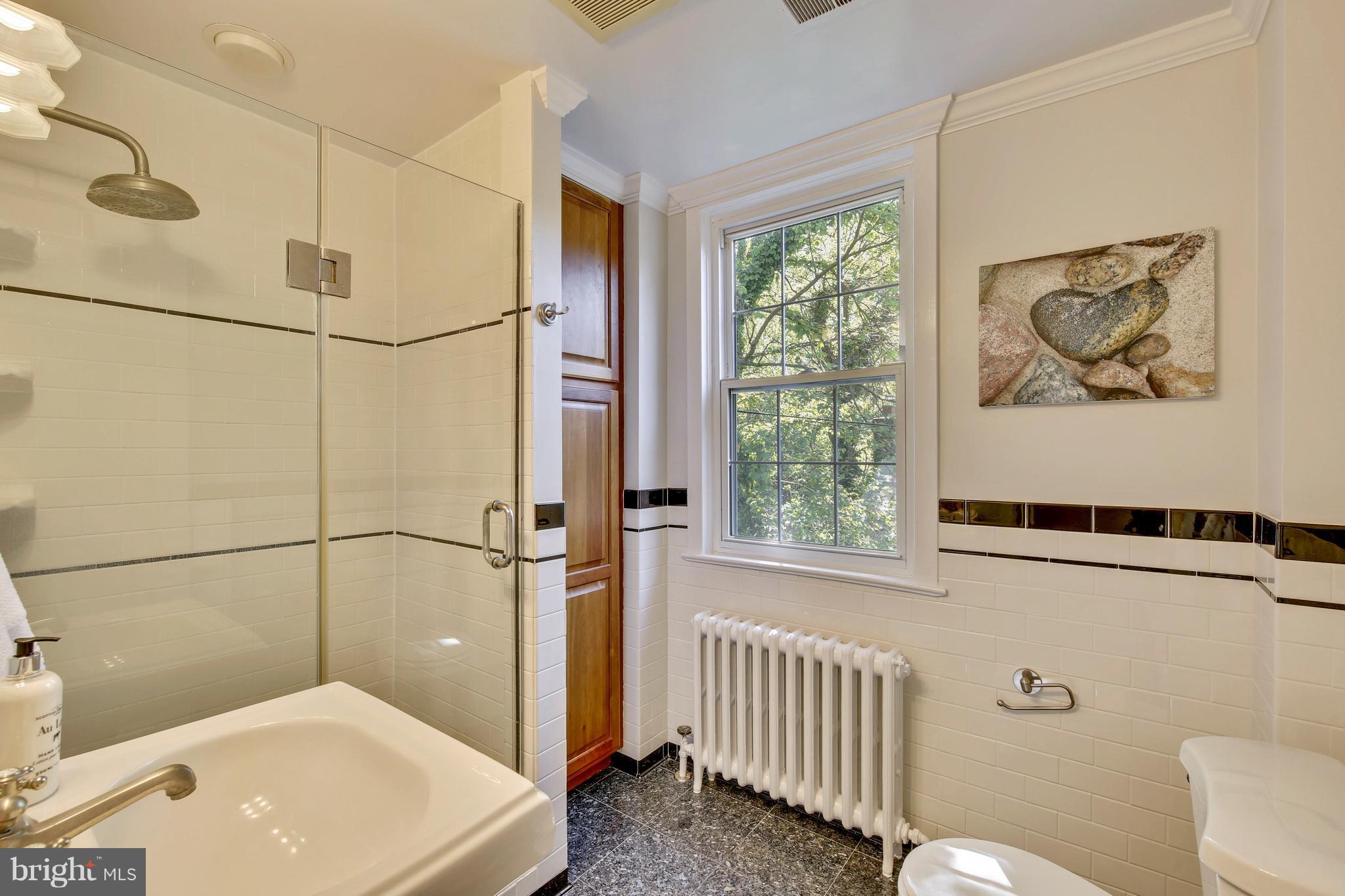 9129 Bradford Road Silver Spring, MD 20901 - Photo 24 of 26 a bathroom with a sink a window and a shower