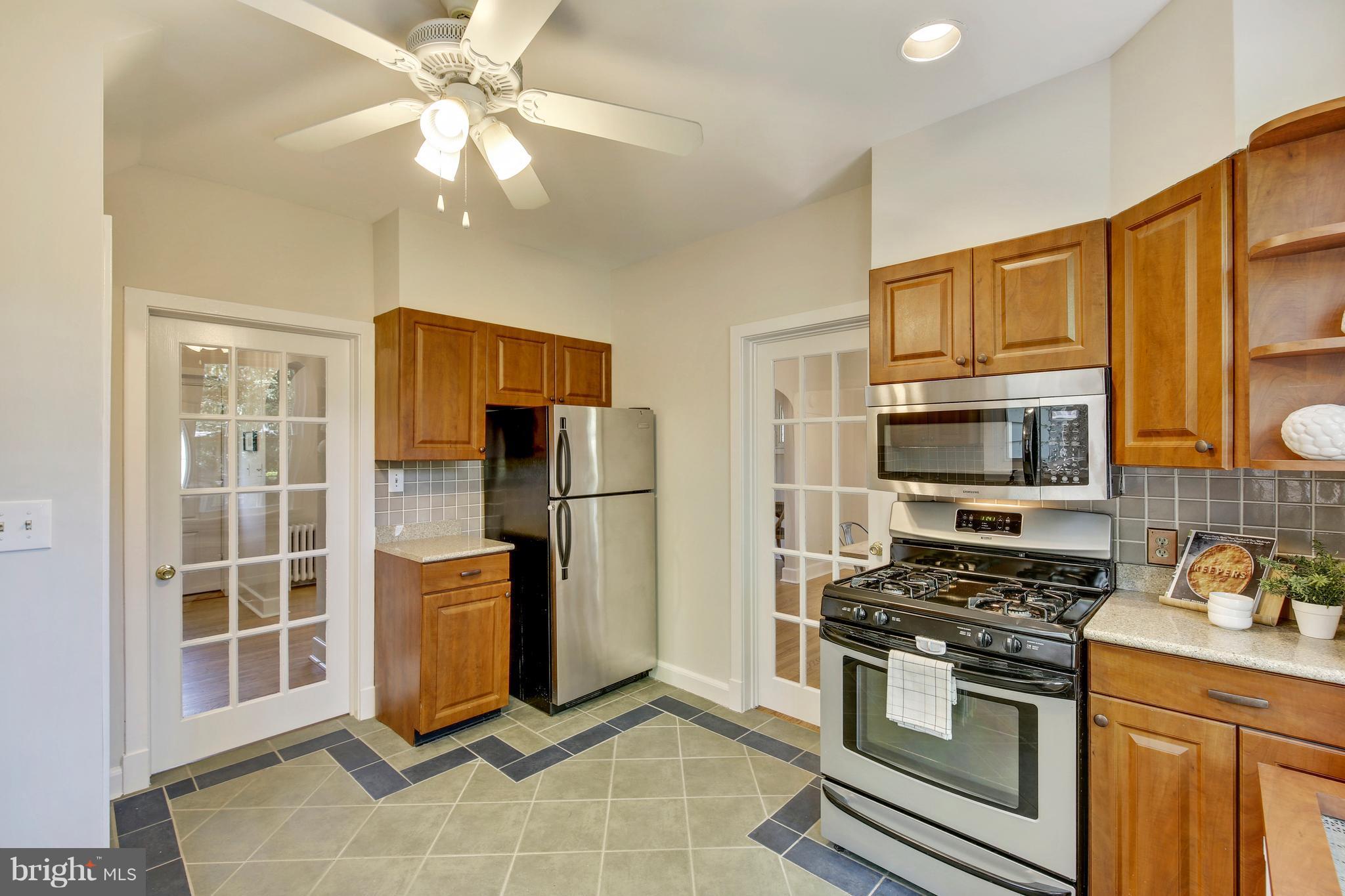 9129 Bradford Road Silver Spring, MD 20901 - Photo 9 of 26 a kitchen with stainless steel appliances granite countertop a refrigerator oven stove a sink dishwasher and a refrigerator with wooden floor