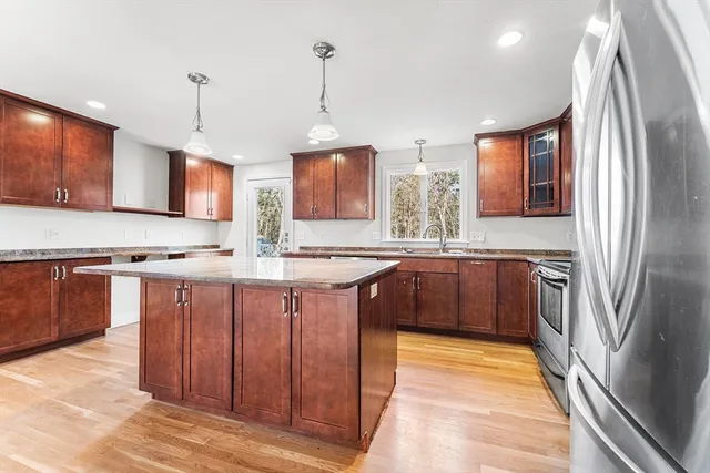 a kitchen with stainless steel appliances granite countertop a sink a stove and a refrigerator