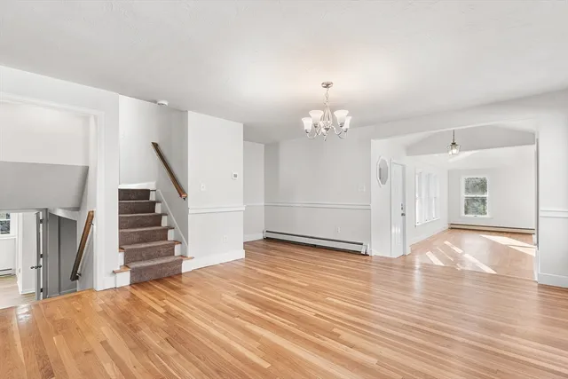 a view of a livingroom with wooden floor and stairs