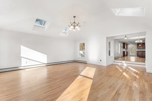 a view of a livingroom with wooden floor and a chandelier