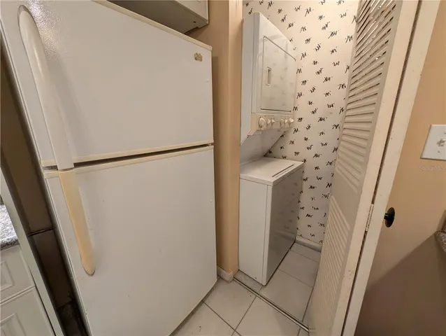 a white refrigerator freezer and a stove sitting inside of a kitchen