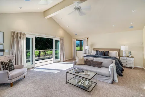 a spacious bedroom with a bed a couch and a large window