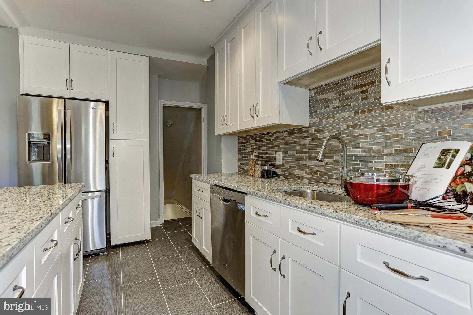 5922 Hillen Road Baltimore, MD 21239 - Photo 11 of 24 a kitchen with stainless steel appliances granite countertop a sink stove and refrigerator