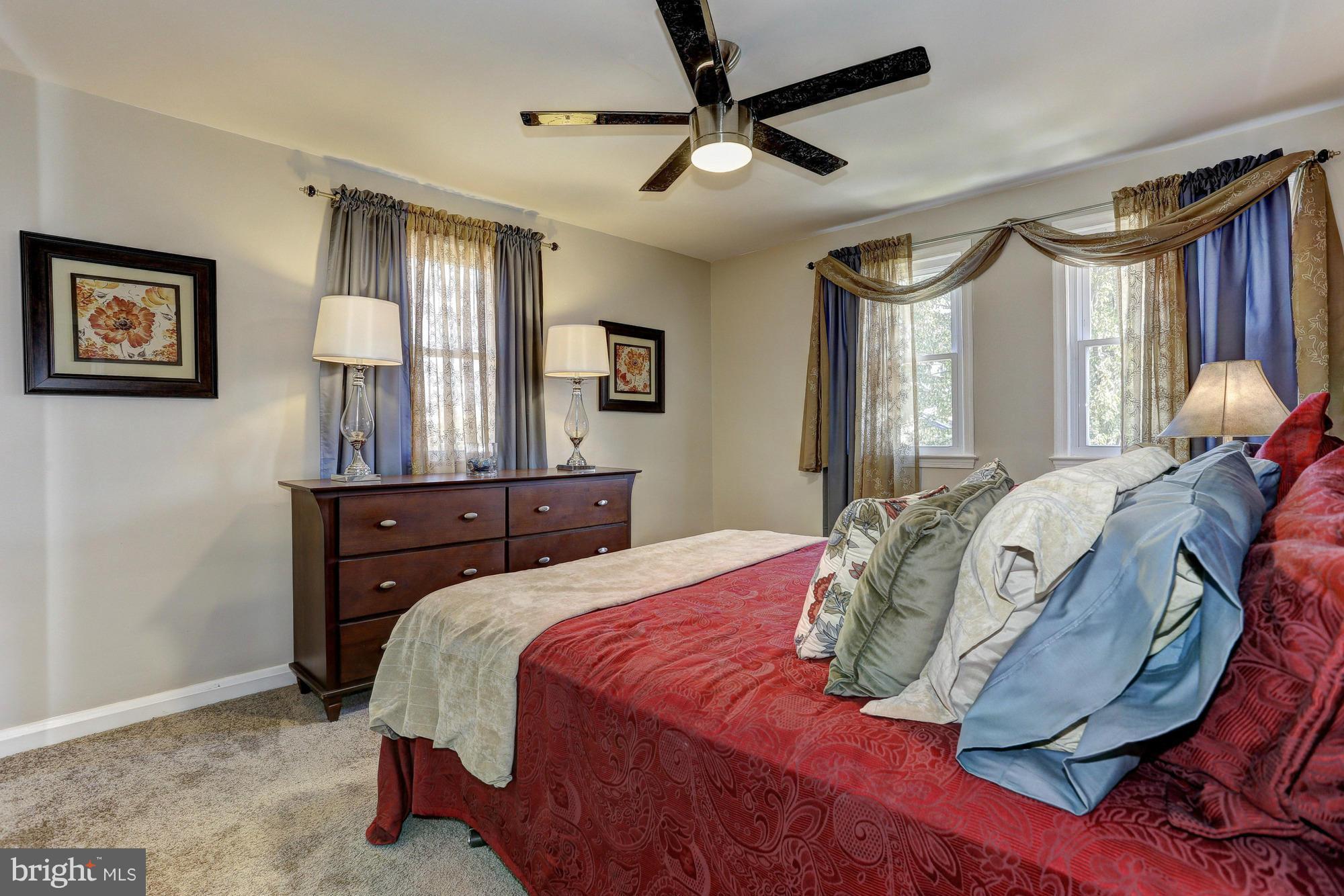 5922 Hillen Road Baltimore, MD 21239 - Photo 12 of 24 a bedroom with a bed mirror on desk and a window