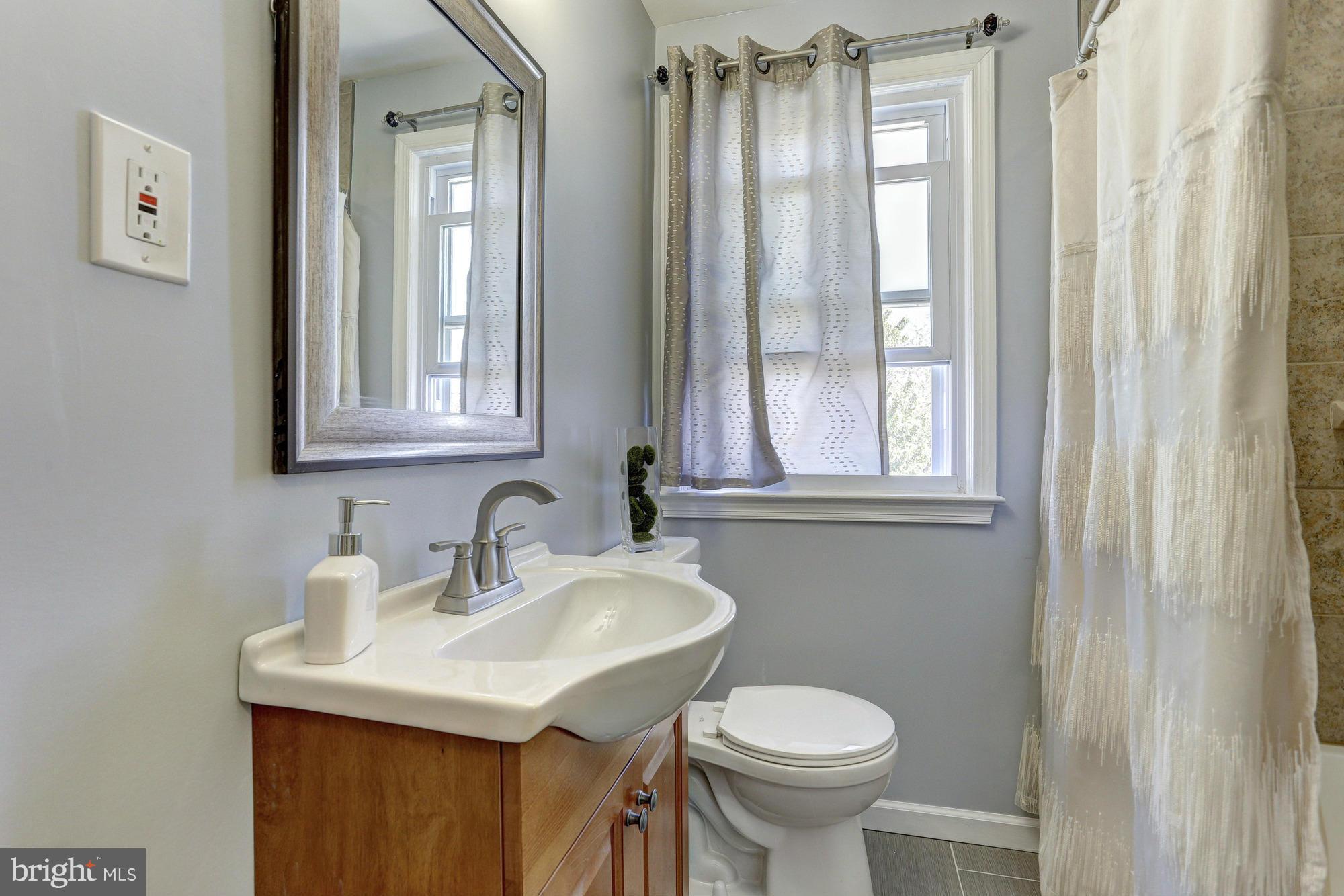 5922 Hillen Road Baltimore, MD 21239 - Photo 15 of 24 a bathroom with a toilet sink and mirror