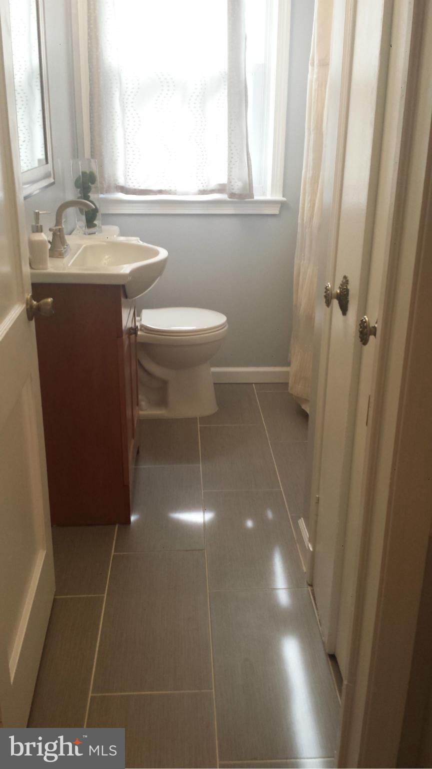 5922 Hillen Road Baltimore, MD 21239 - Photo 17 of 24 a bathroom with a sink a toilet and a mirror