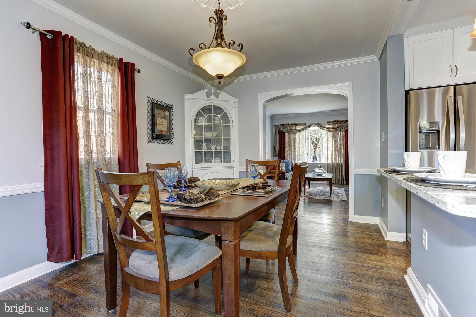 5922 Hillen Road Baltimore, MD 21239 - Photo 6 of 24 a dining room with furniture a chandelier and wooden floor