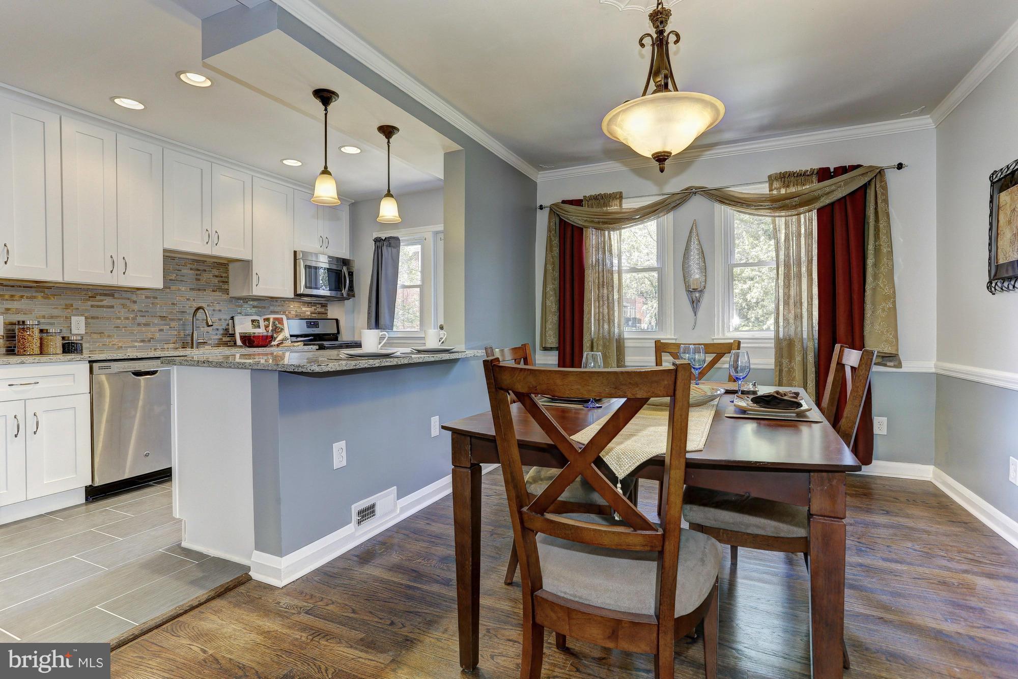 5922 Hillen Road Baltimore, MD 21239 - Photo 7 of 24 a kitchen with stainless steel appliances kitchen island granite countertop a stove a sink and a microwave