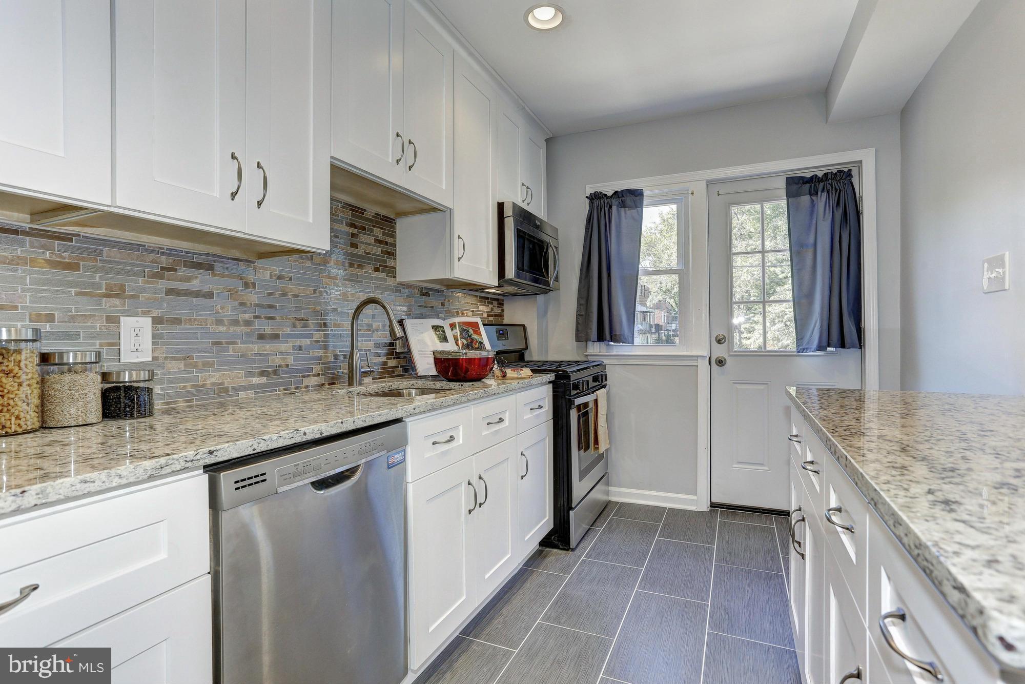 5922 Hillen Road Baltimore, MD 21239 - Photo 9 of 24 a kitchen with granite countertop cabinets stainless steel appliances a sink and window