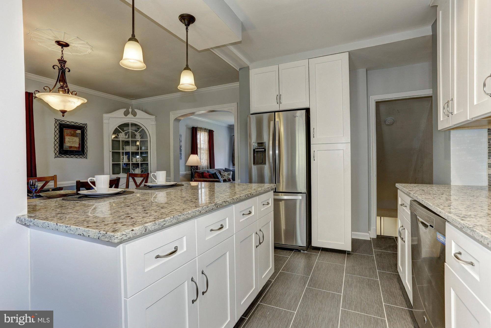 5922 Hillen Road Baltimore, MD 21239 - Photo 10 of 24 a bathroom with a granite countertop sink a large mirror and a refrigerator