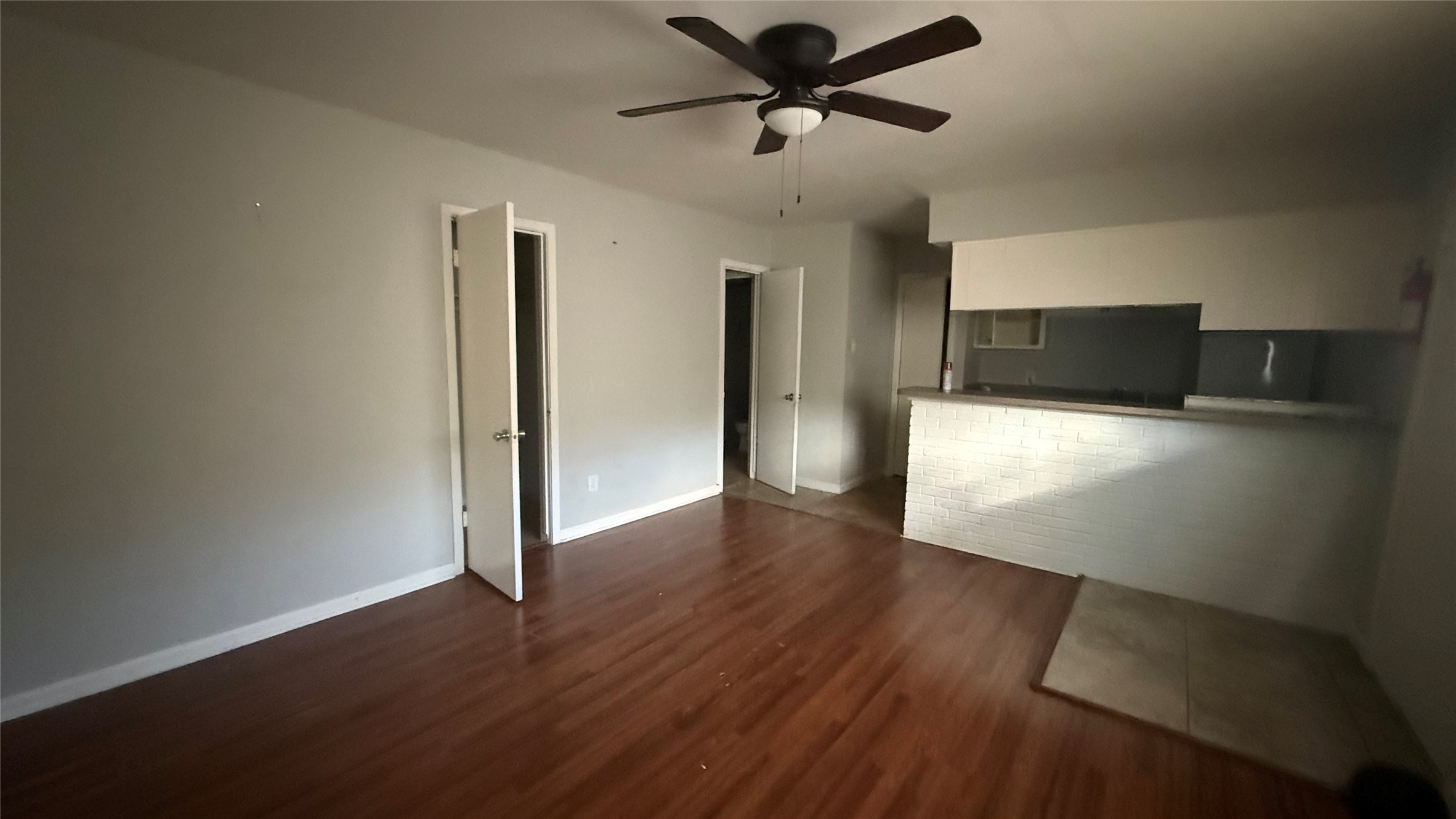 a view of a livingroom with wooden floor and a ceiling fan