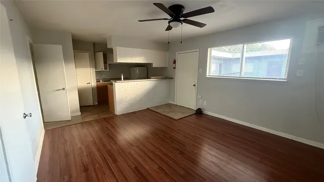 a view of empty room with wooden floor and window