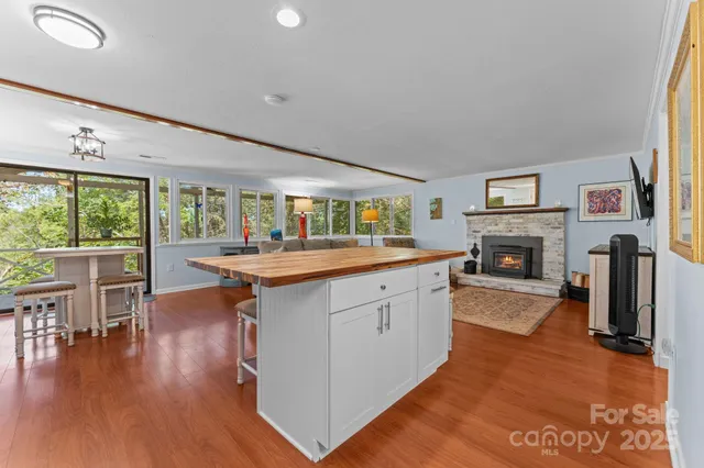 a open kitchen with stainless steel appliances granite countertop a large window and a fireplace