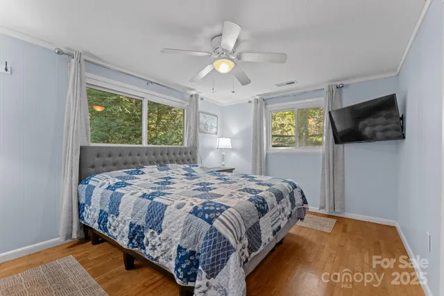 a bedroom with a bed and a flat tv screen on dresser