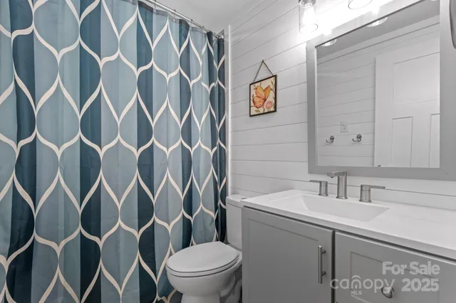 a bathroom with a sink and mirror with toilet