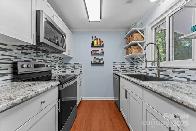 a kitchen with stainless steel appliances granite countertop a stove and a sink