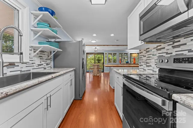 a kitchen with stainless steel appliances kitchen island granite countertop a stove a sink and a microwave