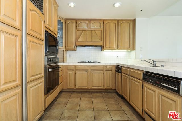 a kitchen with stainless steel appliances granite countertop a sink and cabinets