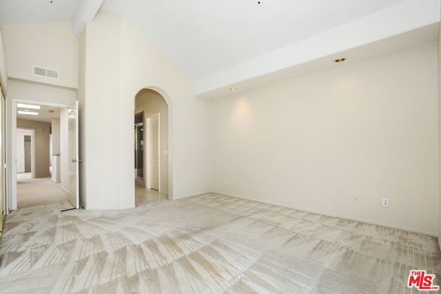 a view of a livingroom with wooden floor and a bedroom