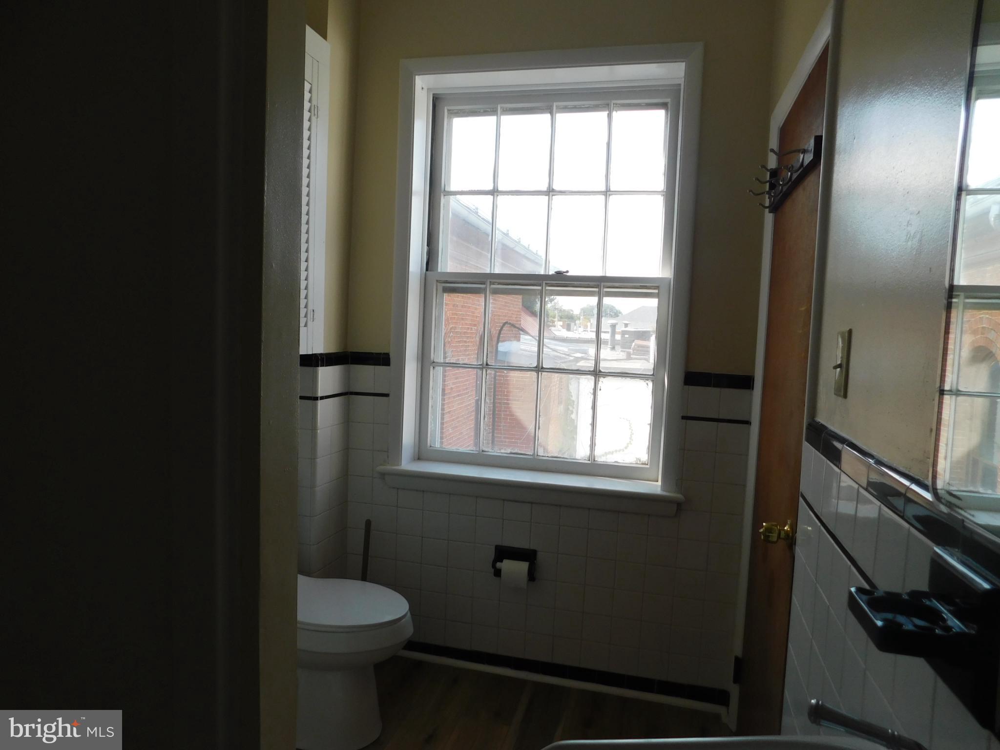 113 West Boscawen Street, Unit 3 Winchester, VA 22601 - Photo 15 of 19 a bathroom with a toilet sink and window
