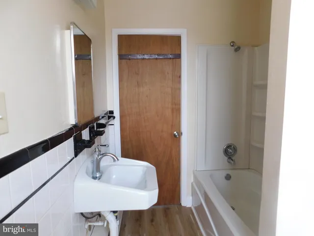 a bathroom with a tub sink and mirror