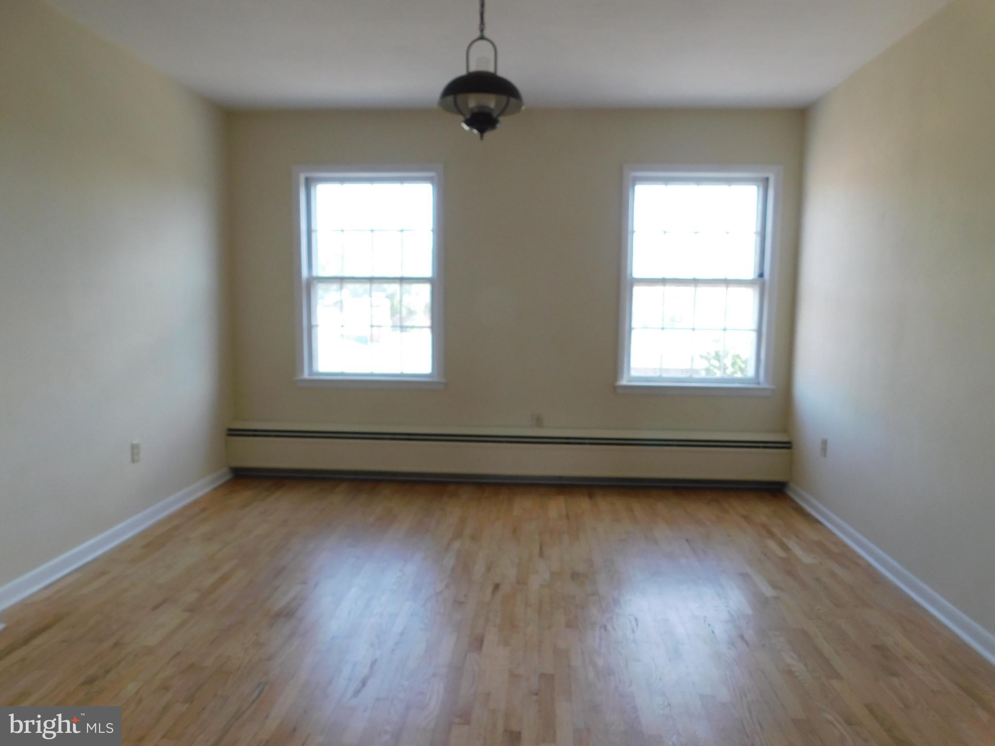 113 West Boscawen Street, Unit 3 Winchester, VA 22601 - Photo 7 of 19 an empty room with wooden floor and windows