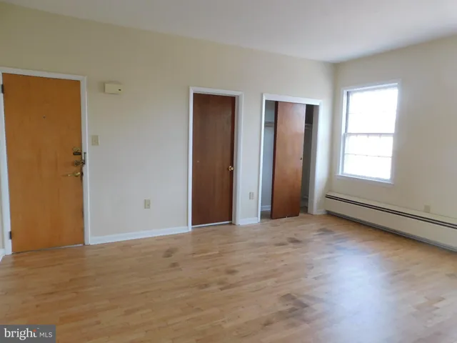 an empty room with windows and closet