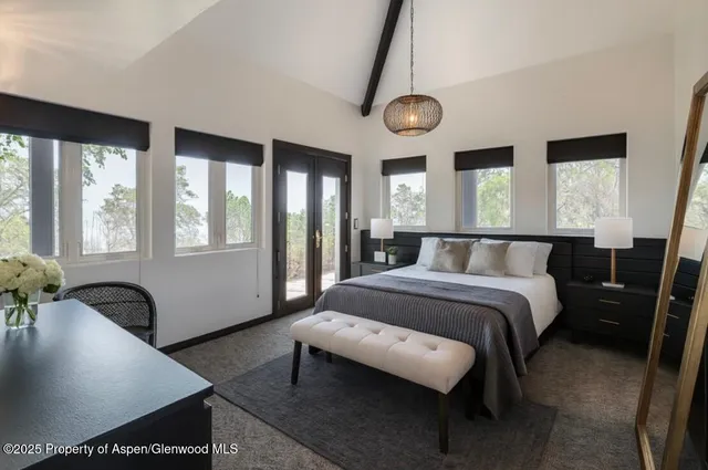 a bedroom with a bed and a large window