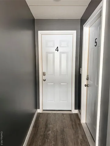 an empty room with wooden floor and mirror