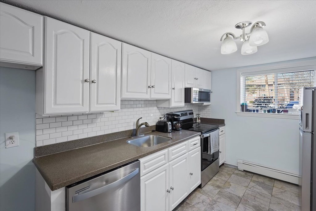 22 Westgate Road, Unit 2 Boston, MA 02467 - Photo 1 of 19 a kitchen with granite countertop white cabinets and stainless steel appliances