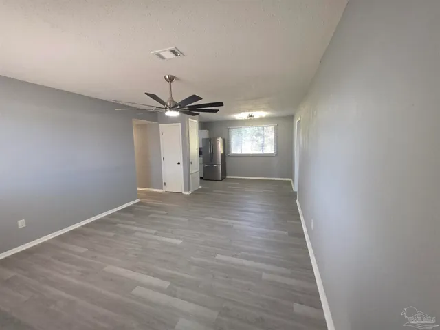 a view of empty room with wooden floor