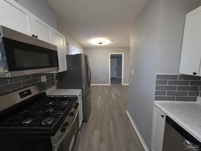 a kitchen with wooden floor and a stove top oven