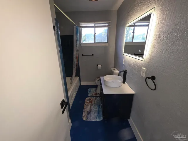 a bathroom with a sink toilet and window
