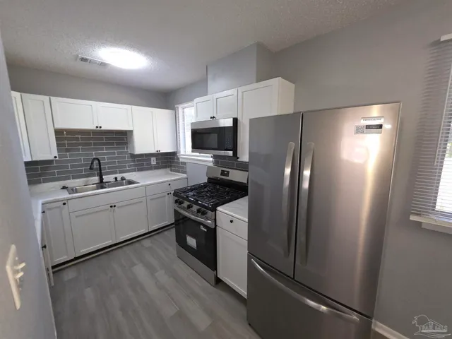 a kitchen with a refrigerator stove and sink