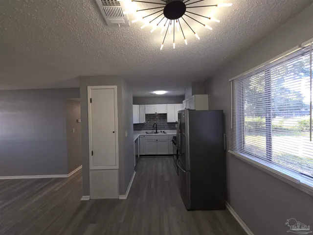 a view of a kitchen with a sink wooden floor and a window