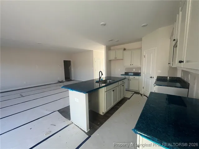 a bathroom with a granite countertop toilet and a sink