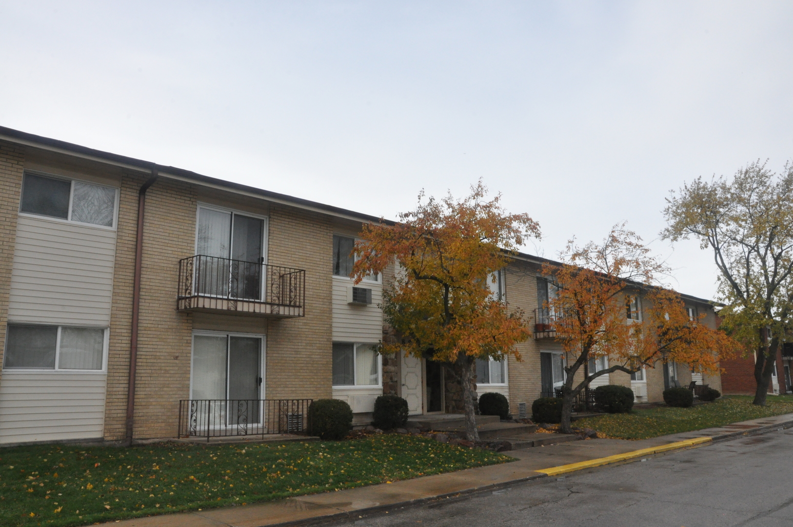 8900 David Place, Unit 1F Des Plaines, IL 60016 - Photo 2 of 13 a view of a white house with a tree and plants