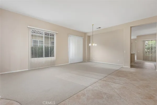 a view of a chandelier in big room and a bathroom