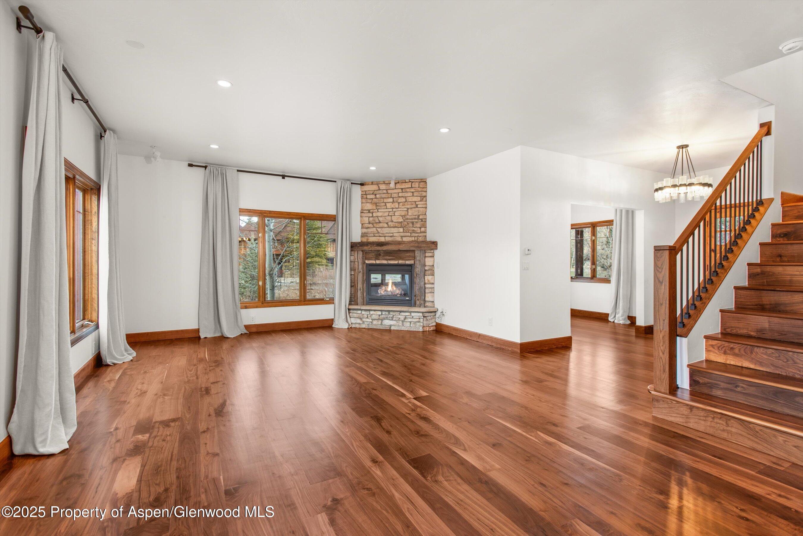 75 Buffalo Lane Carbondale, CO 81623 - Photo 9 of 49 a view of an empty room with wooden floor fireplace and windows
