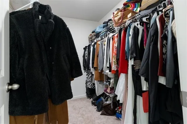 a view of walk in closet with clothes and shoes