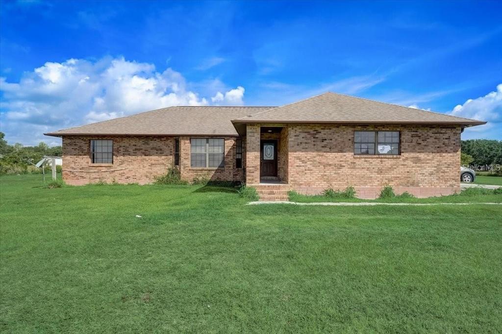 2950 Flounder Creek Road Mims, FL 32754 - Photo 1 of 29 a front view of a house with a garden