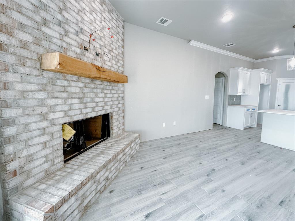 1341 Promised Land Road Hewitt, TX 76643 - Photo 6 of 34 a view of empty room with a fireplace and wooden floor