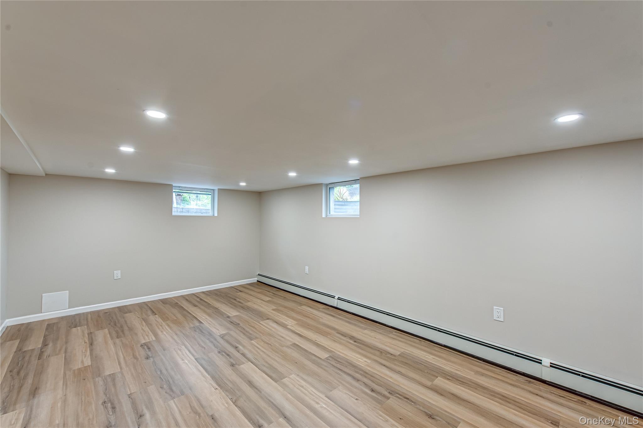 31 Terrell Street Patchogue, NY 11772 - Photo 14 of 21 an empty room with wooden floor and windows