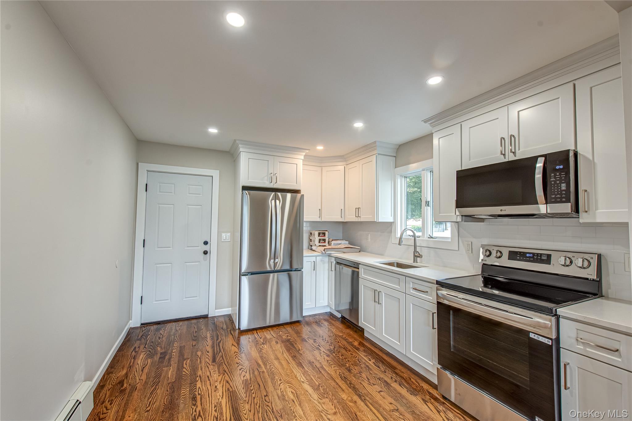 31 Terrell Street Patchogue, NY 11772 - Photo 3 of 21 a kitchen with stainless steel appliances a refrigerator stove and microwave