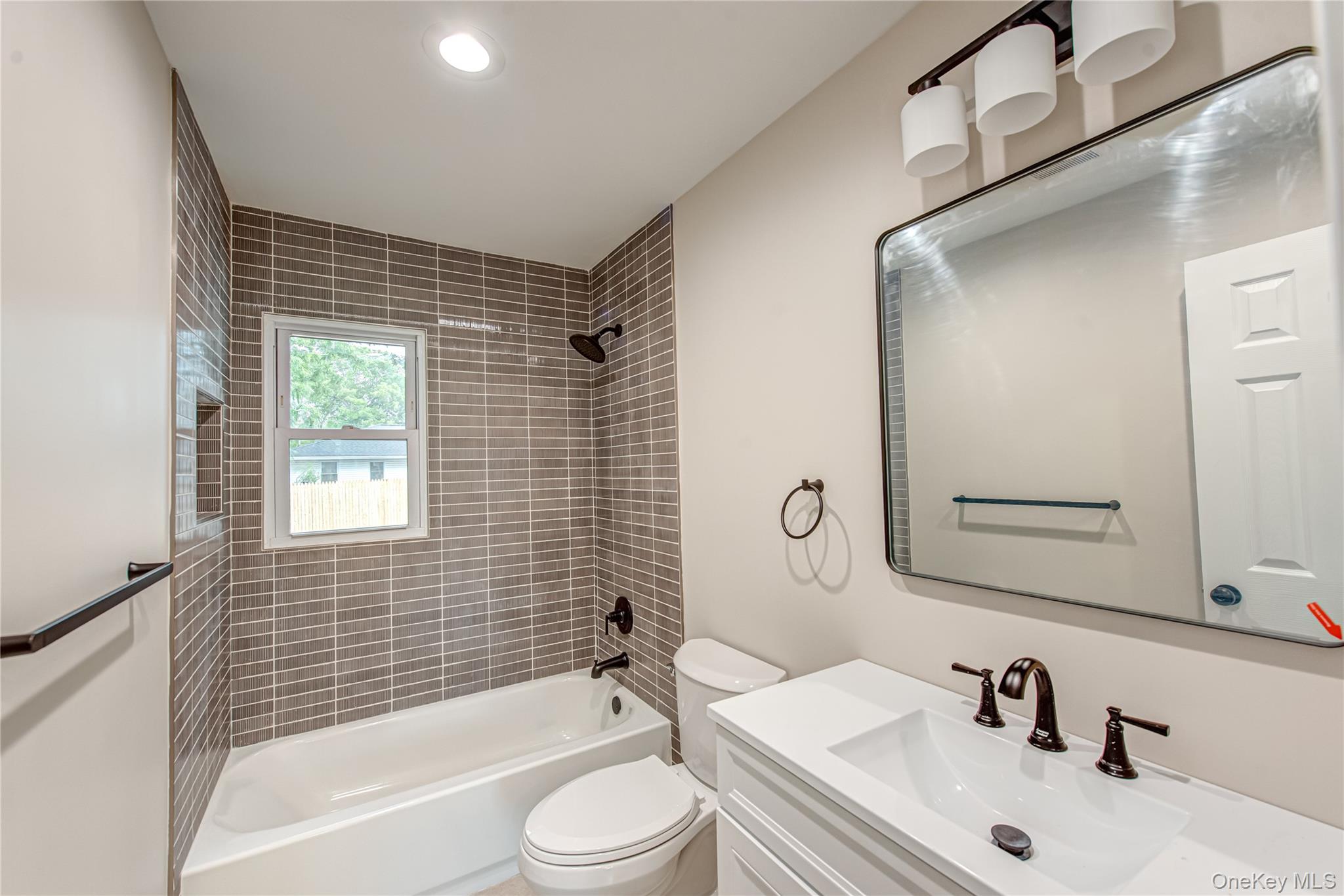 31 Terrell Street Patchogue, NY 11772 - Photo 4 of 21 a bathroom with a bathtub shower sink vanity mirror and toilet