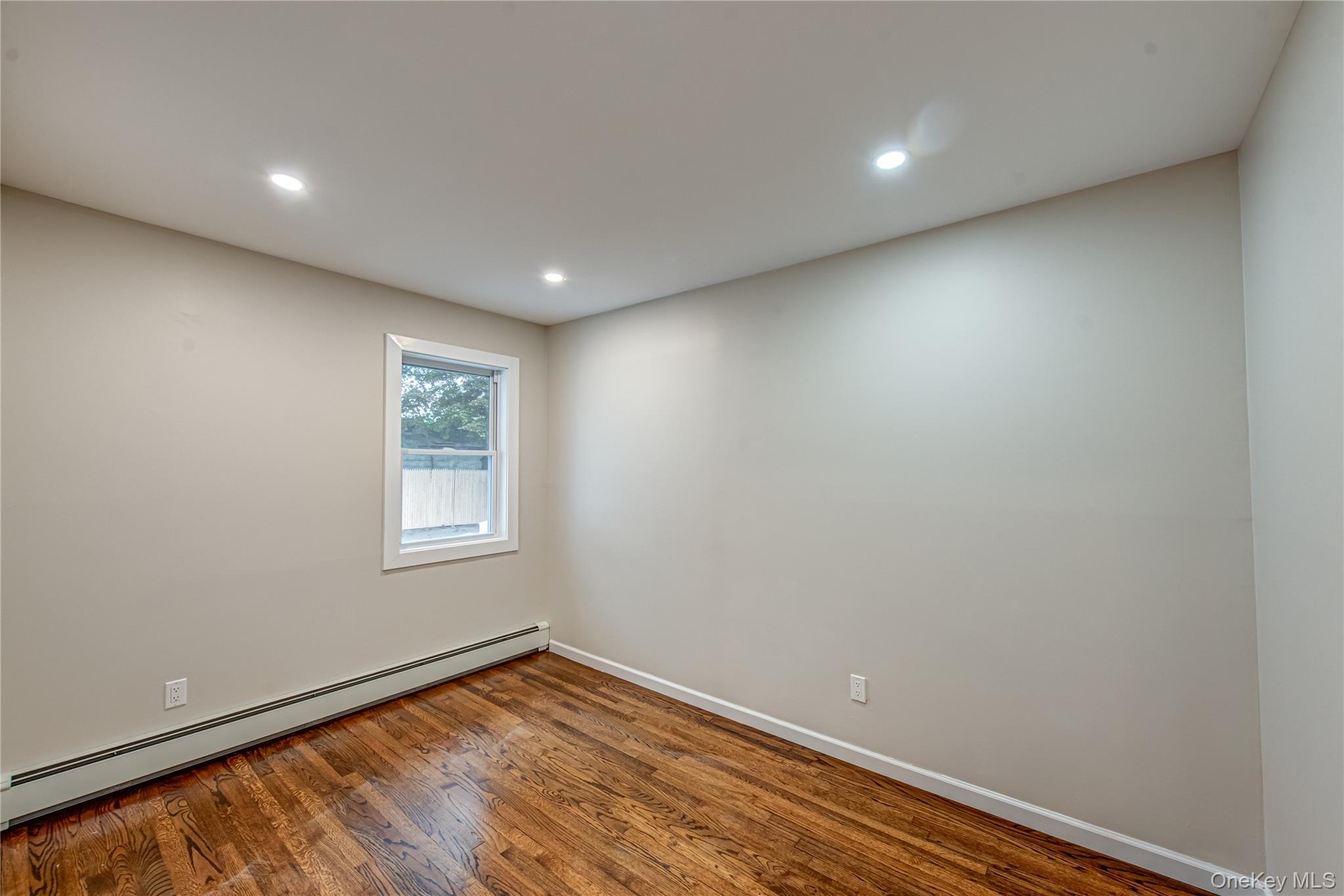 31 Terrell Street Patchogue, NY 11772 - Photo 10 of 21 an empty room with wooden floor and windows